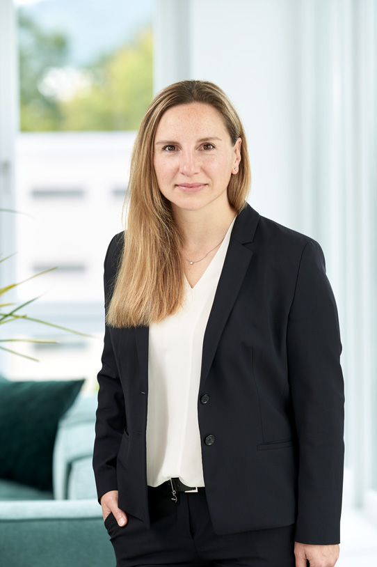 Porträt von Jane Koch in Büro-Umgebung.